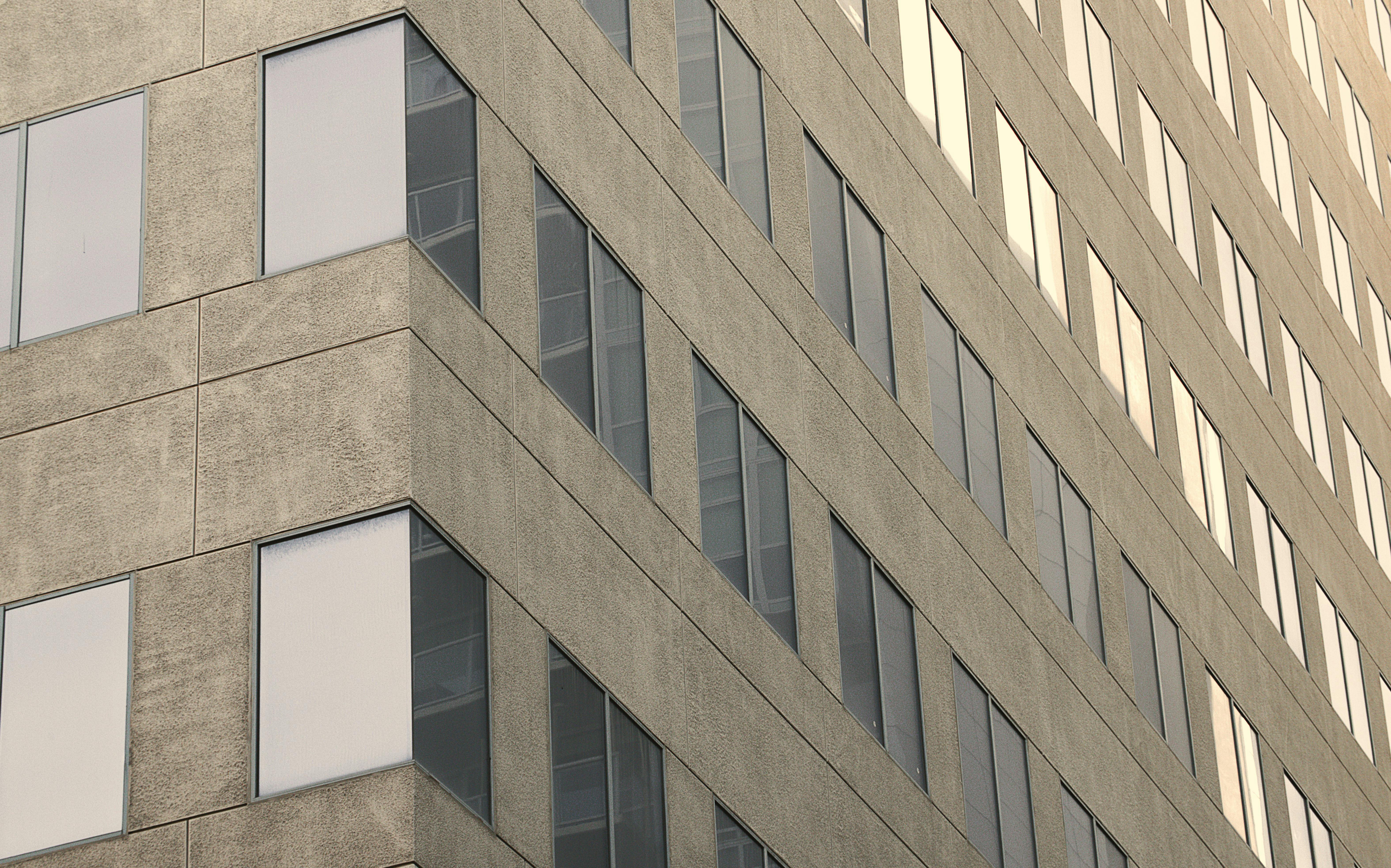 De franc Primer pla d'un edifici d'oficines modern amb una façana geomètrica durant el dia. Foto d'estoc