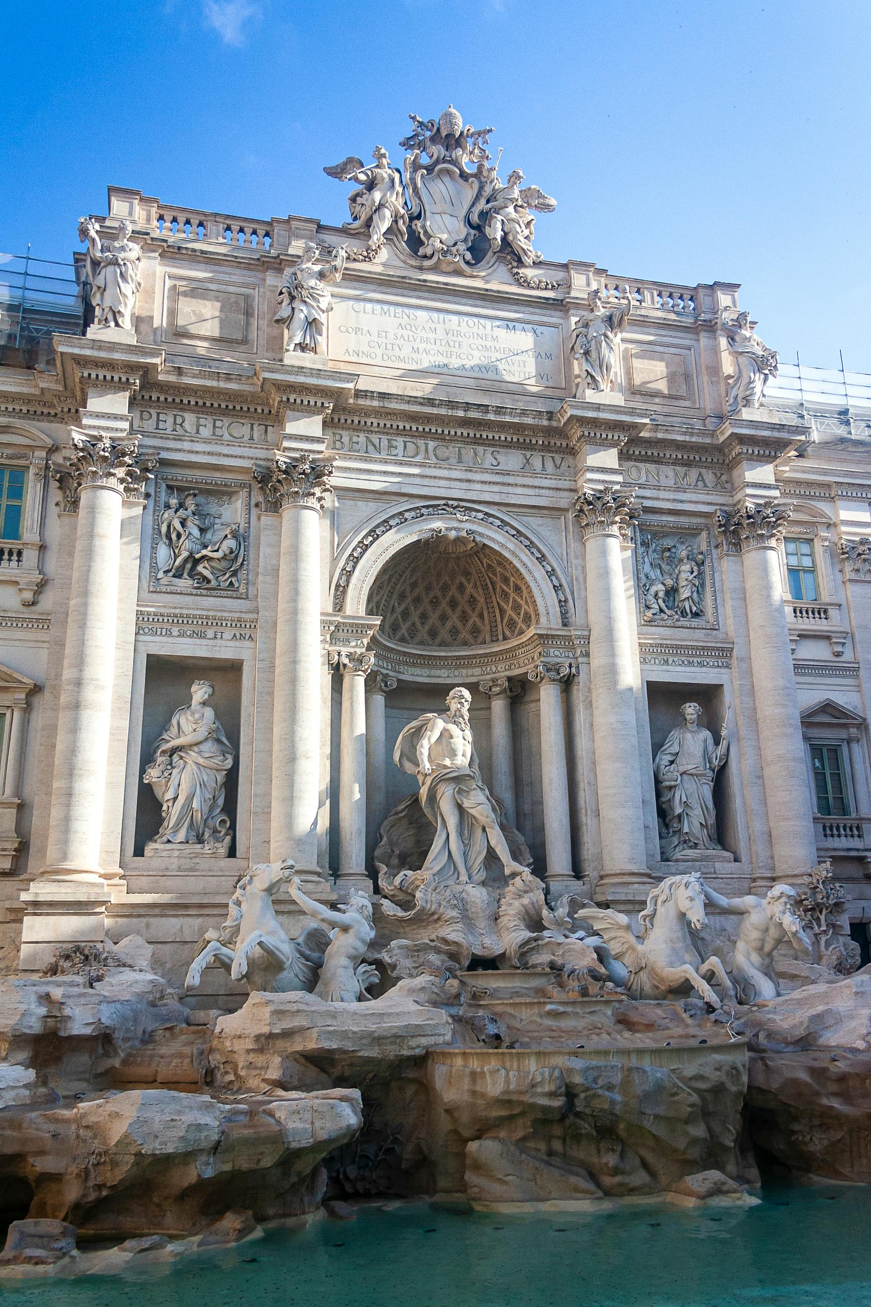 The Trevi Fountain in Rome, a stunning Baroque masterpiece featuring dramatic marble sculptures of Neptune and sea horses, with visitors gathered to toss coins and make wishes in Italy's most famous fountain