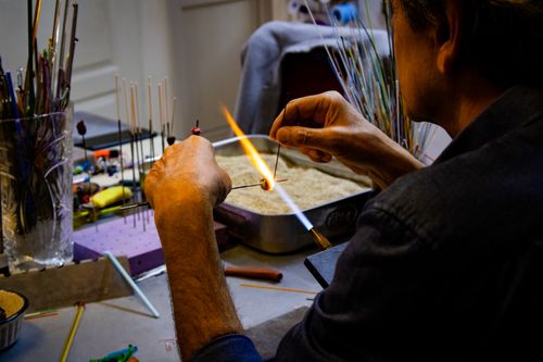 Free A skilled artisan shapes colorful glass beads over a flame in an Ankara workshop. Stock Photo