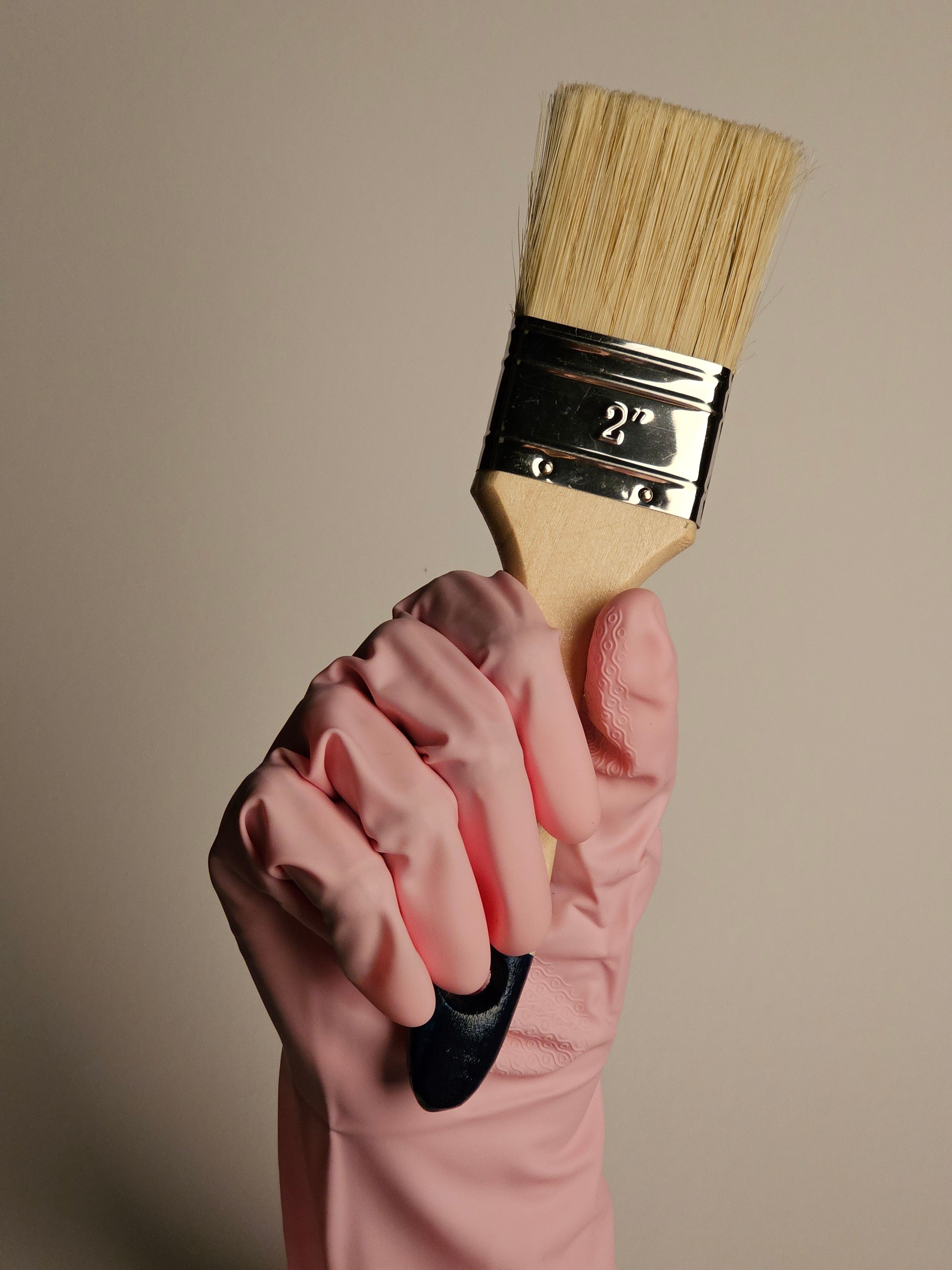 Painter's Hand with Pink Glove Holding Brush · Free Stock Photo