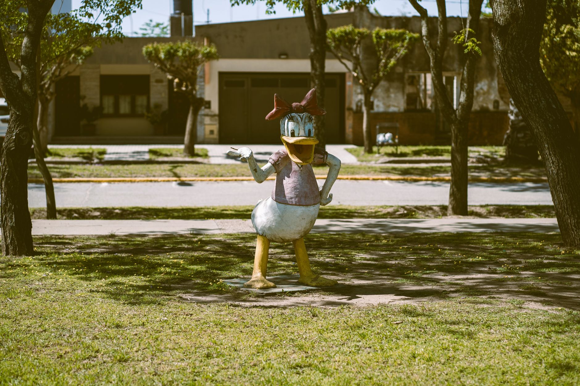 Colorful Daisy Duck statue in a sunny park setting, Morrison, Córdoba, Argentina.