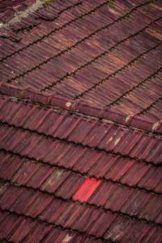 Close-up of aged red roof tiles with unique patterns and textures, perfect for backgrounds.