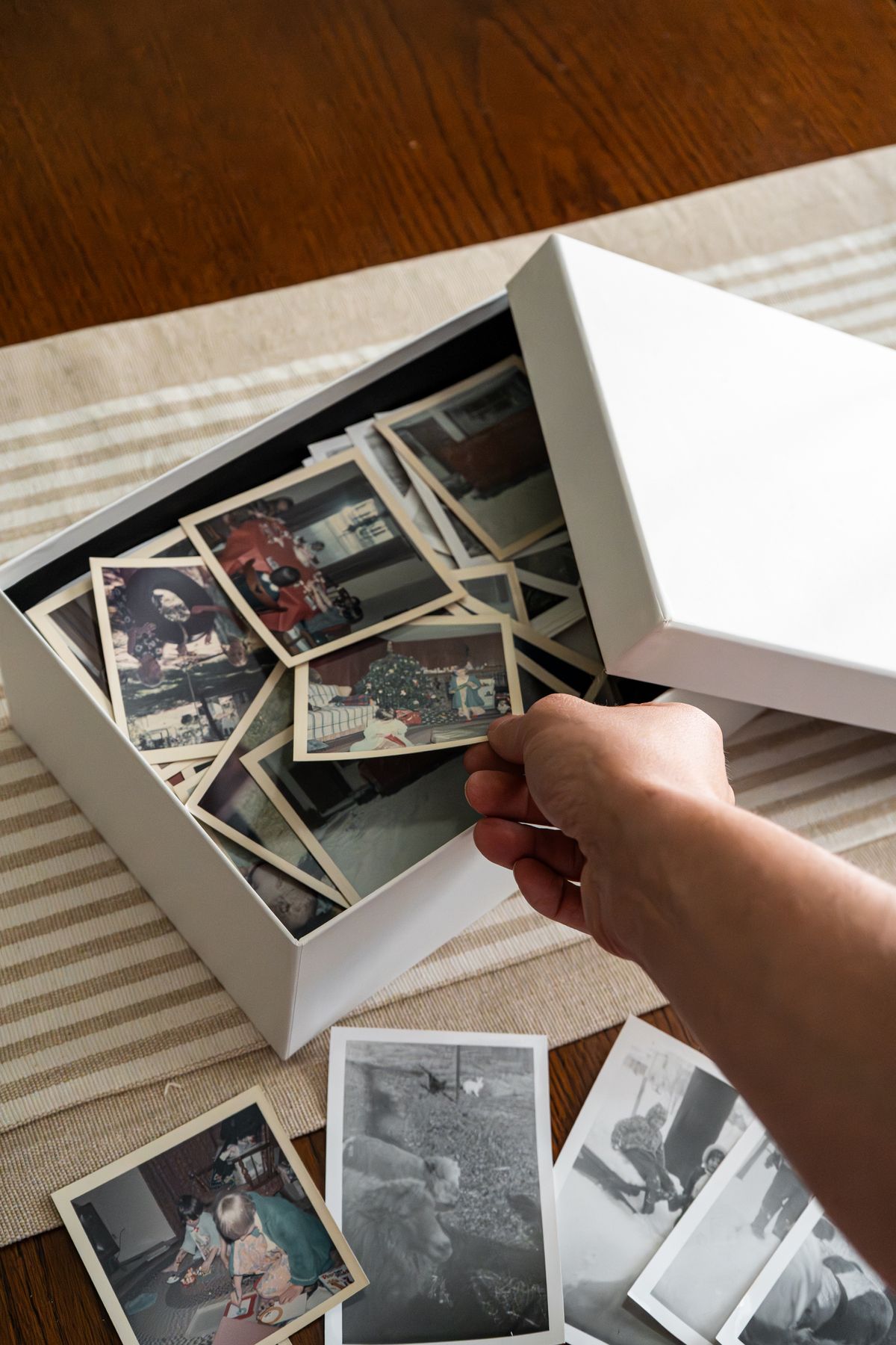 Old family photographs in a vintage box representing childhood money memories