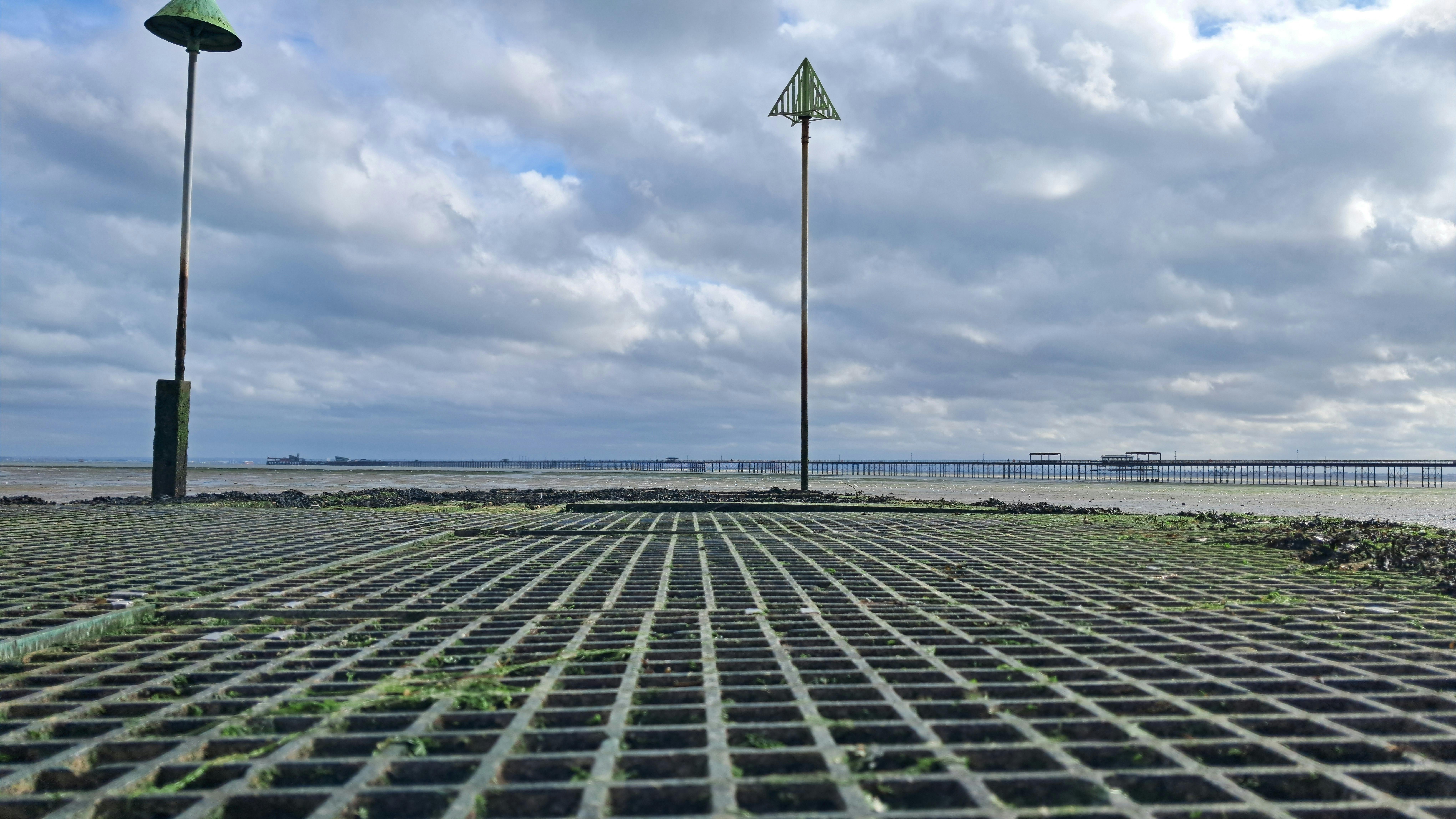 Moody coastal scene with metal grid and cloudy sky near Southend-on-Sea.