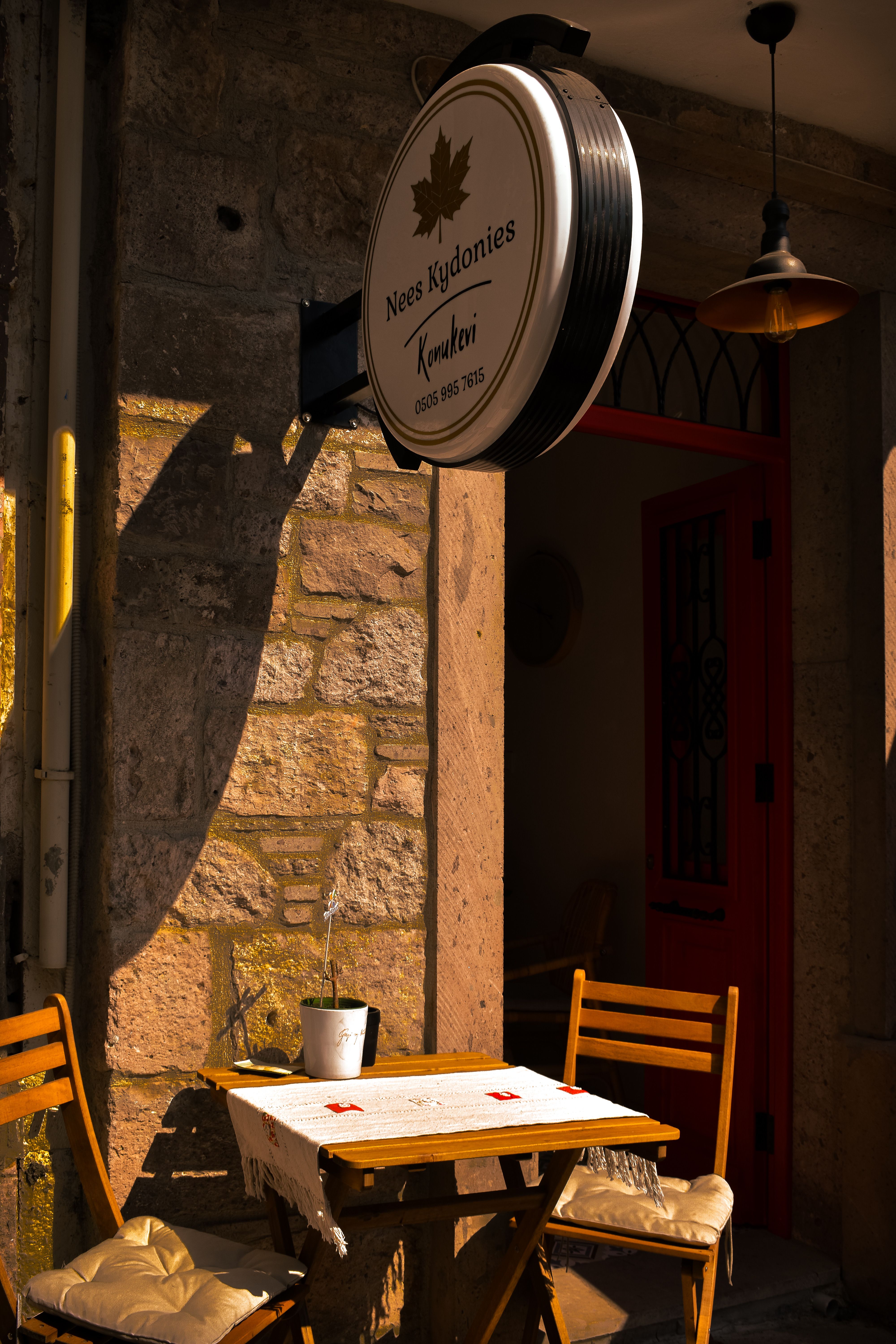 Sunlit outdoor cafe with wooden tables and chairs, perfect for a cozy break.