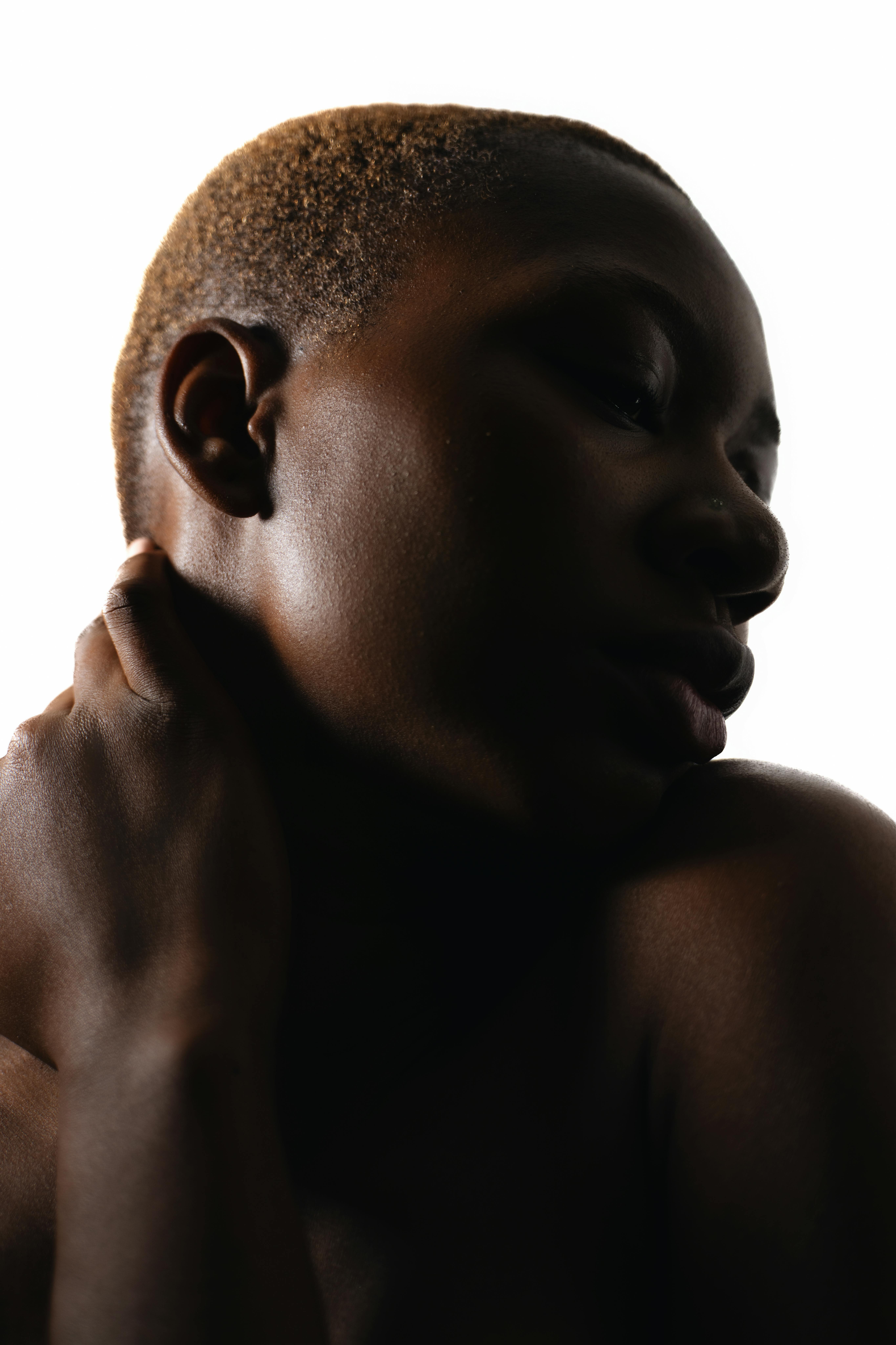 Artistic low-key portrait of a woman with creative backlighting.