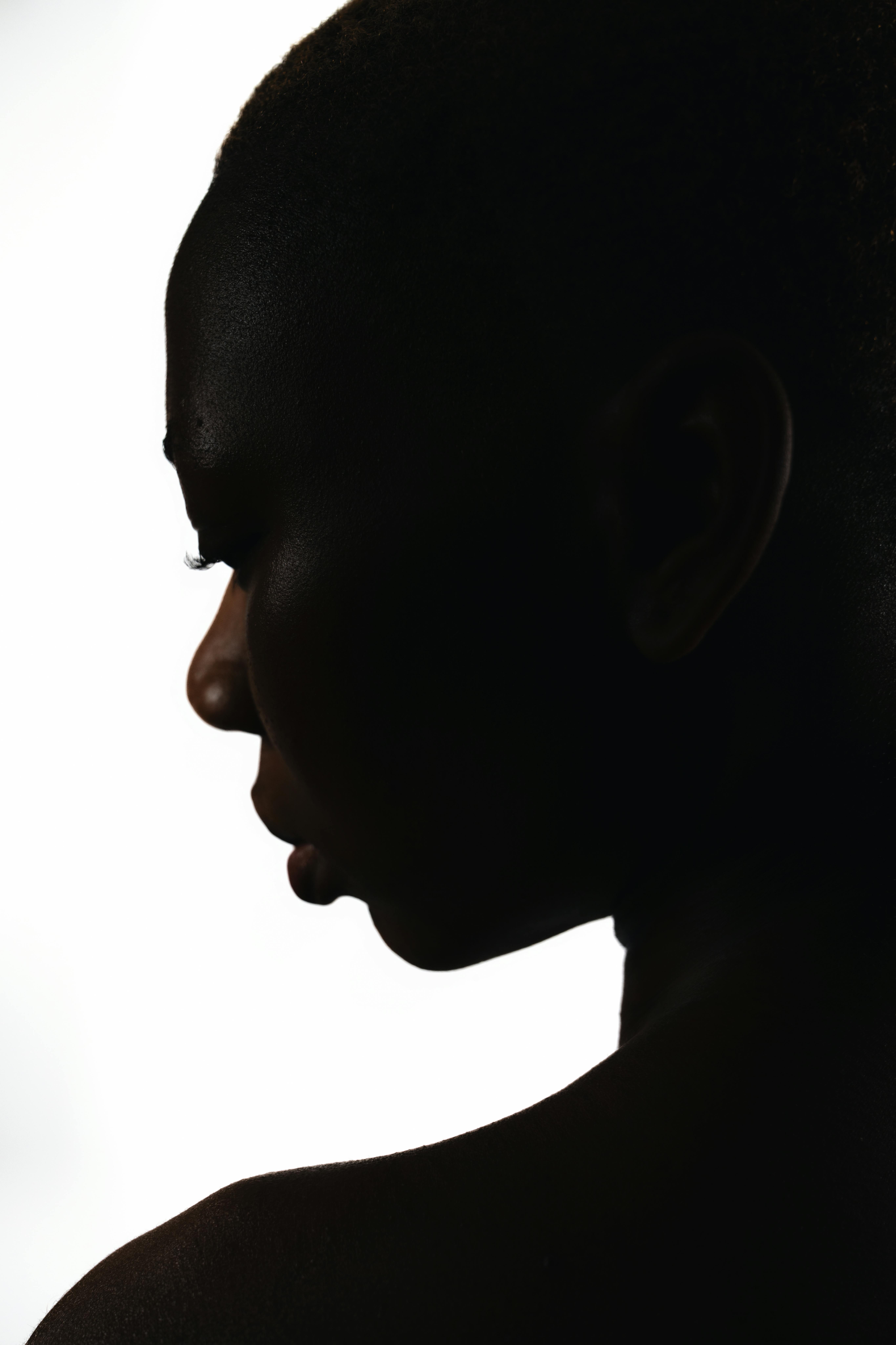 Elegant silhouette of a woman's profile against a white backdrop, highlighting beauty and elegance.