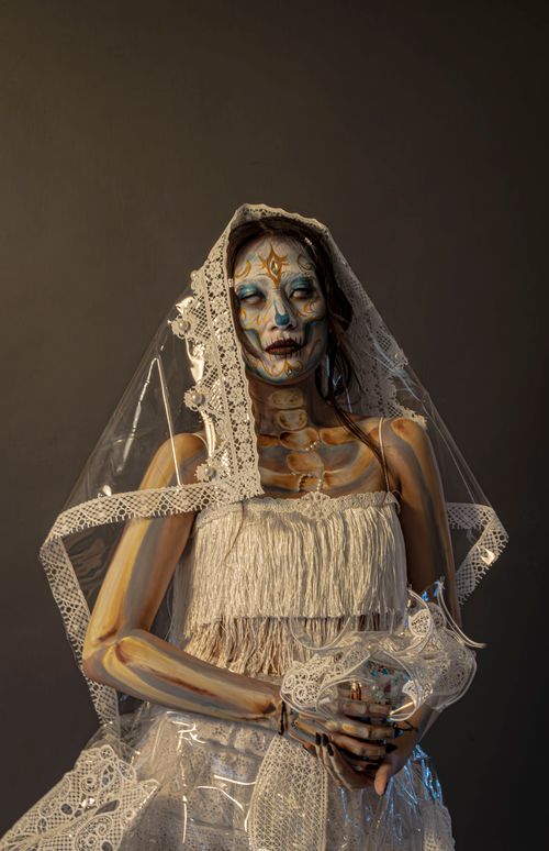 Free A striking portrait of a woman in gothic skeleton makeup and a lace veil, evoking mystery and elegance. Stock Photo