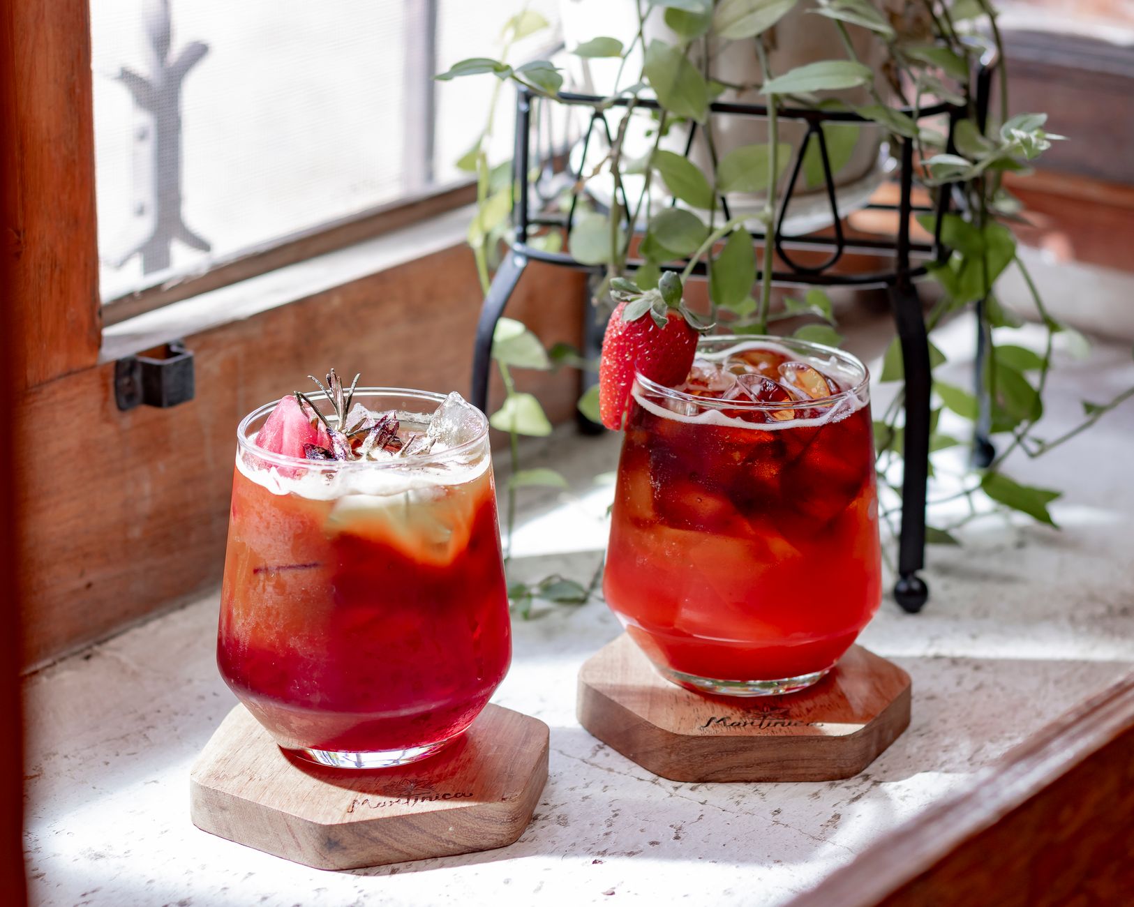 Rosemary Tea Recipe Homemade: A Fresh Brew for Wellness, Focus, and Flavor 5 Two glasses of iced tea with fruits and herbs by a sunny window, exuding freshness.