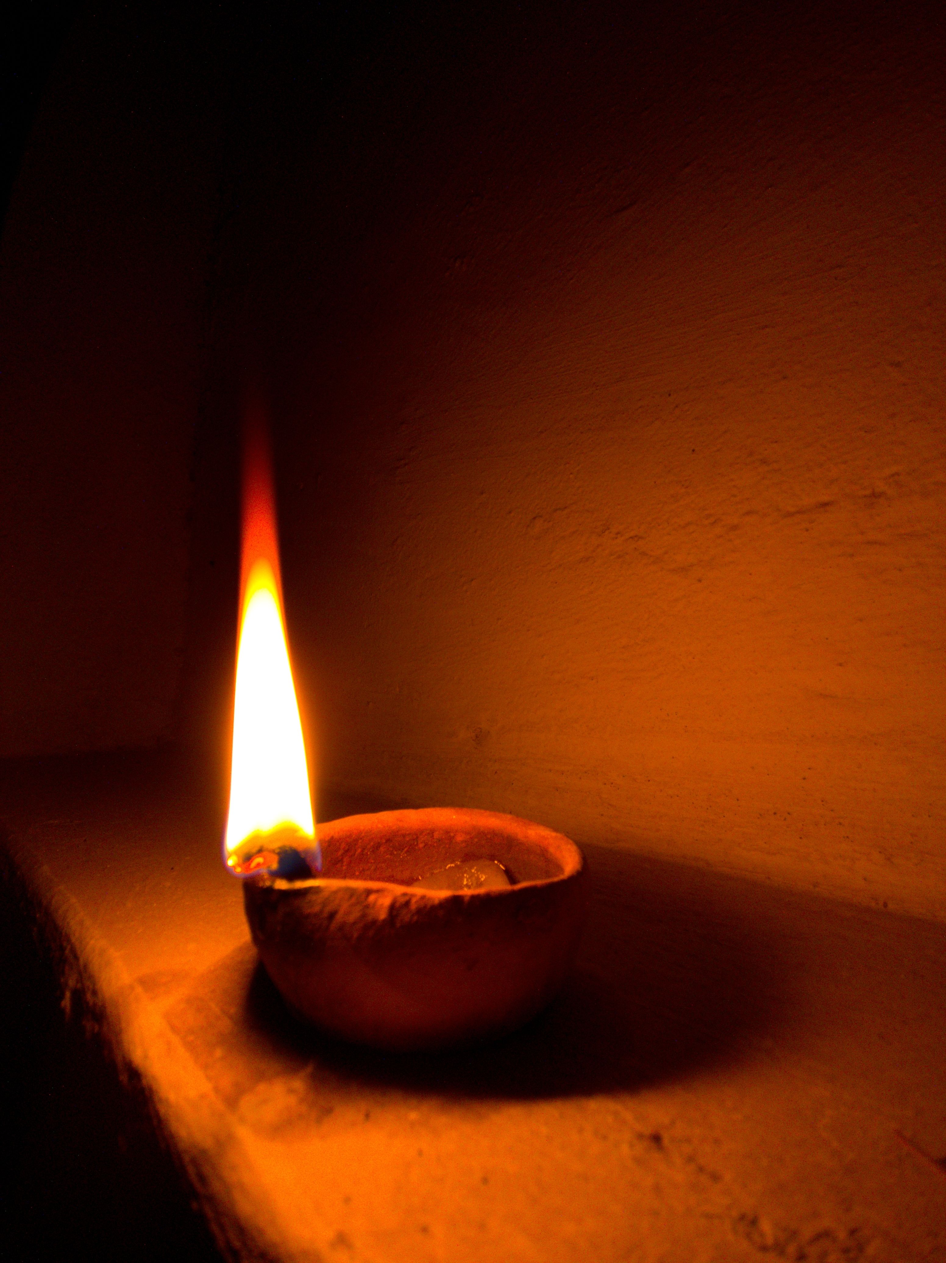 A clay diya casts a warm glow, creating a serene atmosphere.