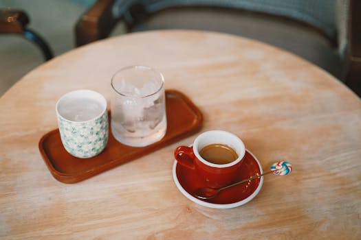 Aesthetic coffee setup with an espresso, ice water, and decorative spoon.