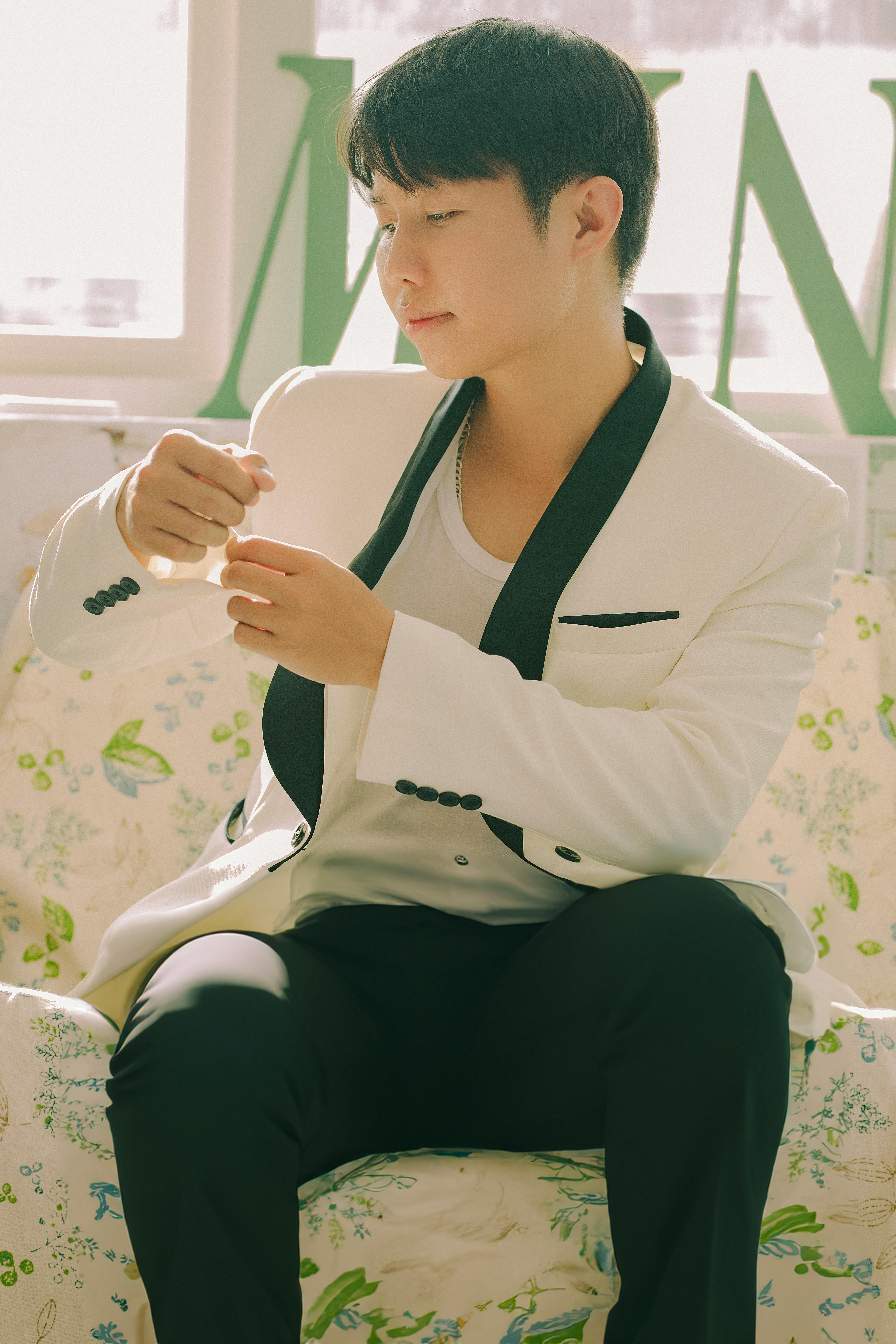 Kostnadsfria Charmig ung man i snygg vit kostym sitter i soligt rum. Stock foto