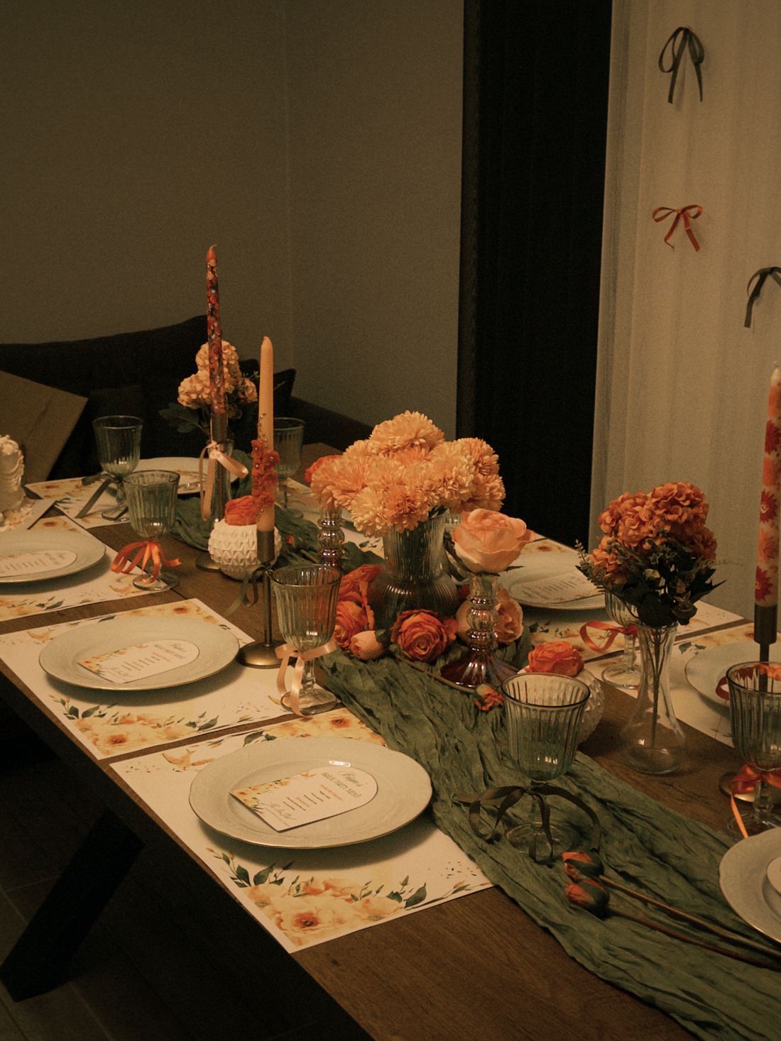 Refined celebration table with floral centerpieces, candles, tableware, and balloons