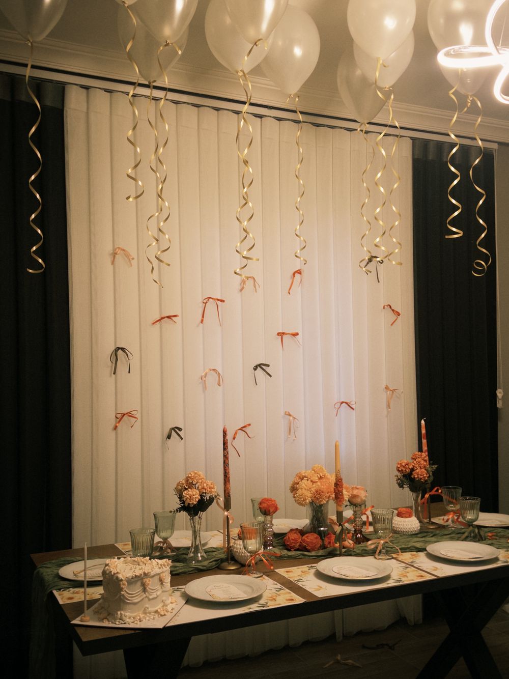 Intimate party table styled with flowers, tableware, and festive balloons