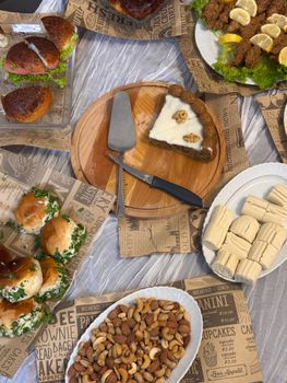 Delicious buffet spread featuring burgers, desserts, nuts, and more on rustic paper decor.
