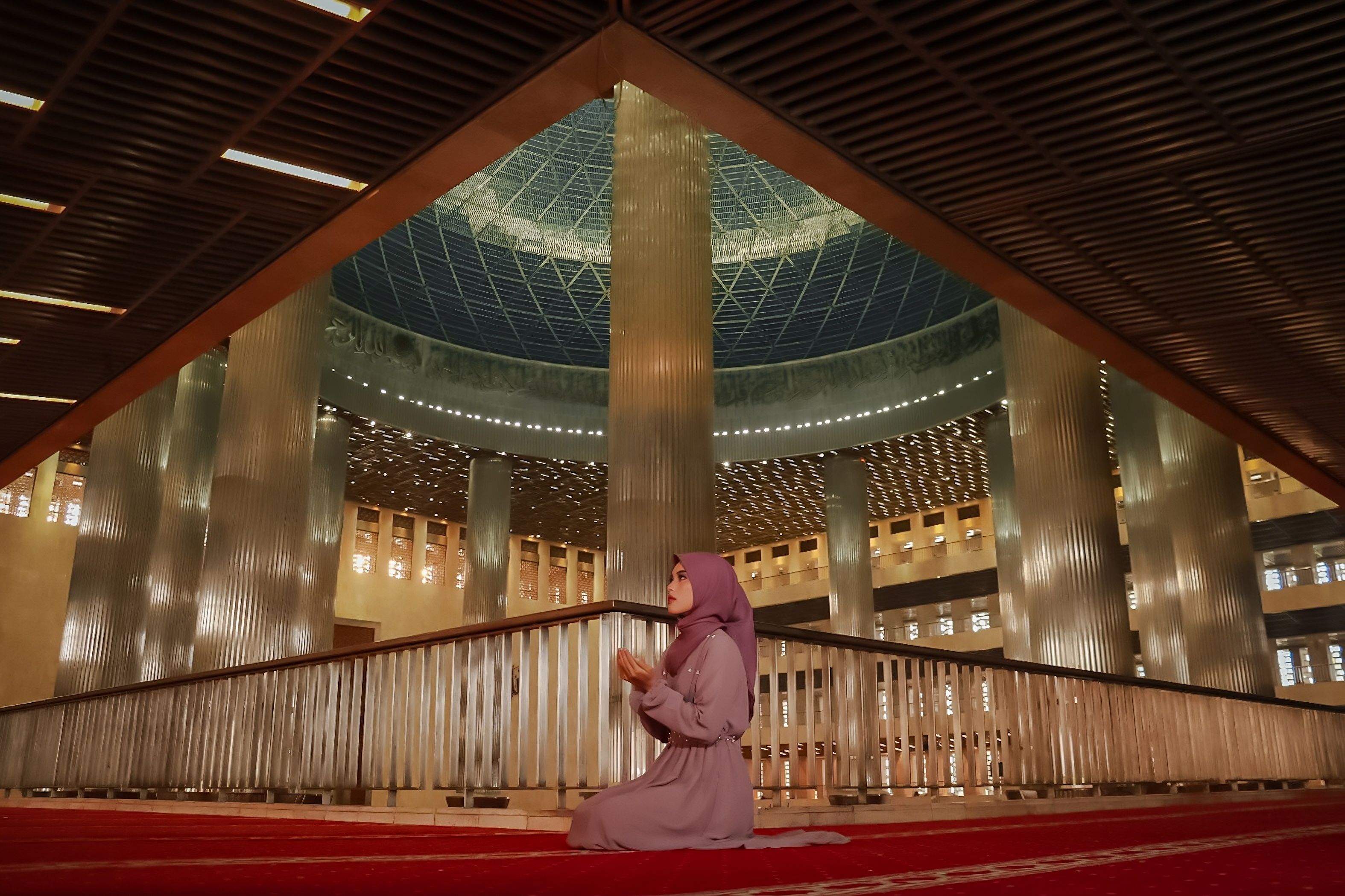 Woman Praying Inside a Grand Mosque Interior · Free Stock Photo