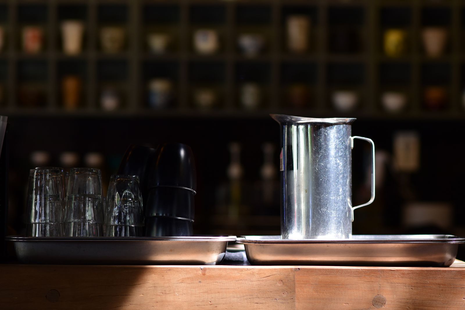 Unbranded stainless-steel milk pitcher standing on a café counter