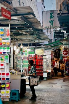 Busy Hong Kong street market with diverse shops and customers, capturing urban life.