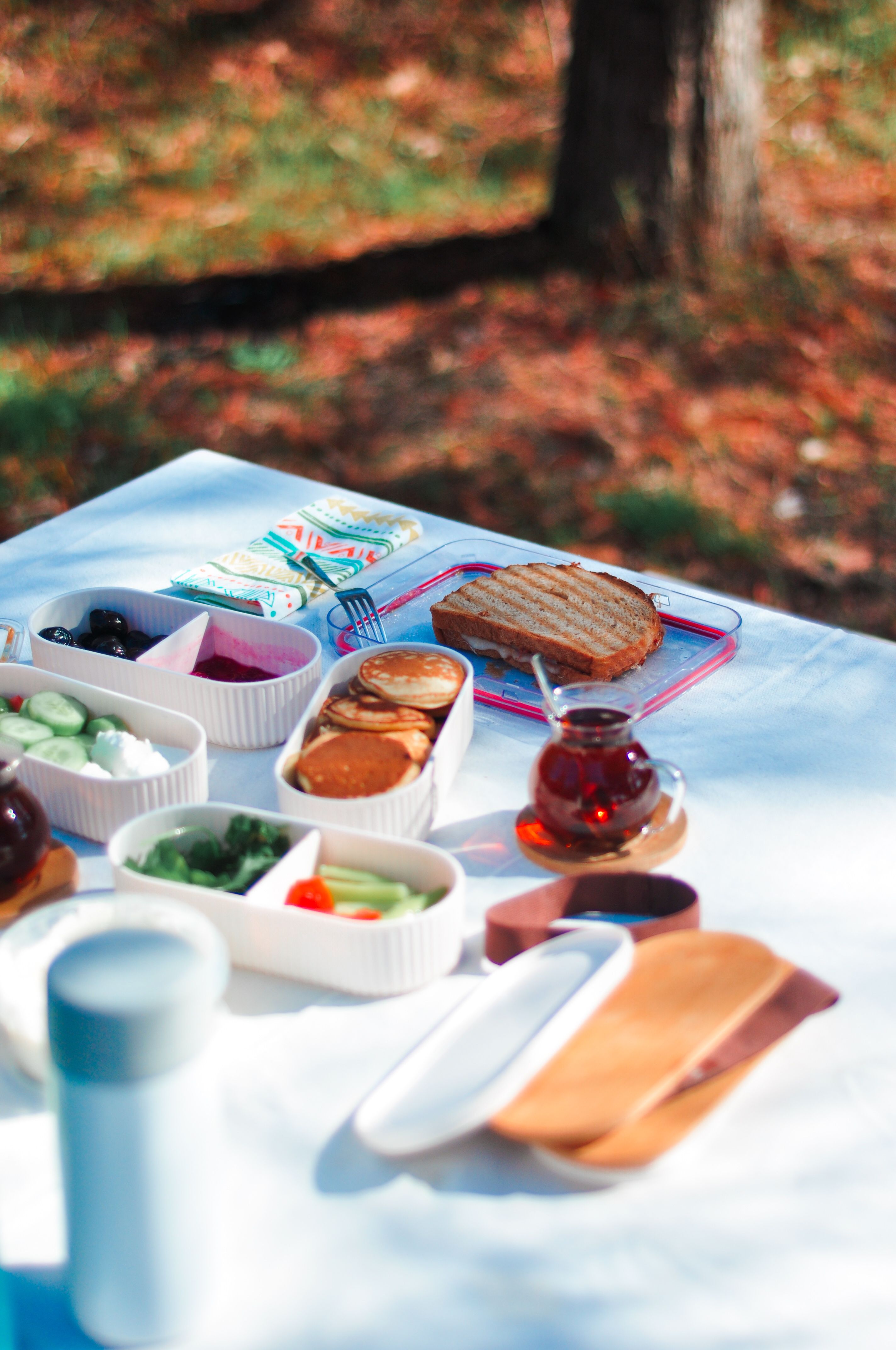 Colorful outdoor picnic setup with snacks and tea on a sunny day.