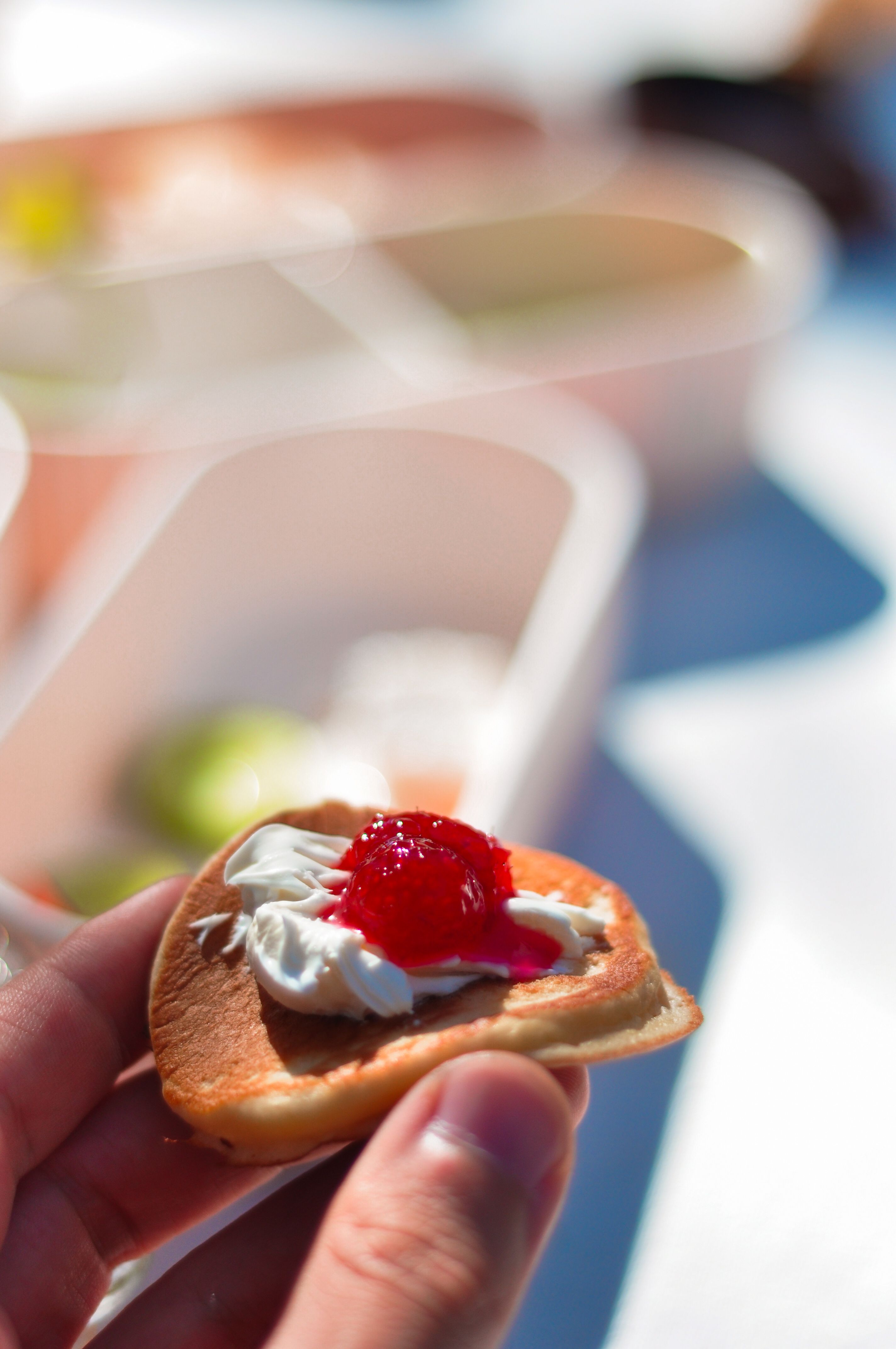 Mini pancake topped with cream and strawberry