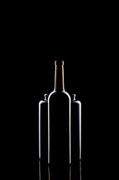 Elegant silhouettes of wine bottles in a minimalist black background setting.