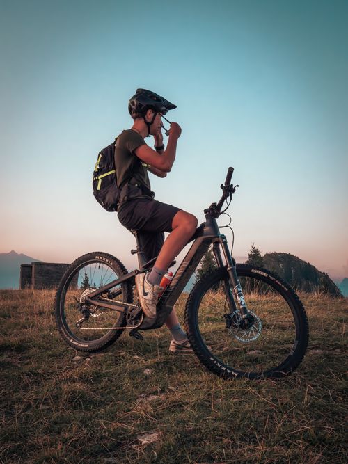 Free Cyclist enjoying sunset in Castione della Presolana, Italy with mountain bike. Stock Photo