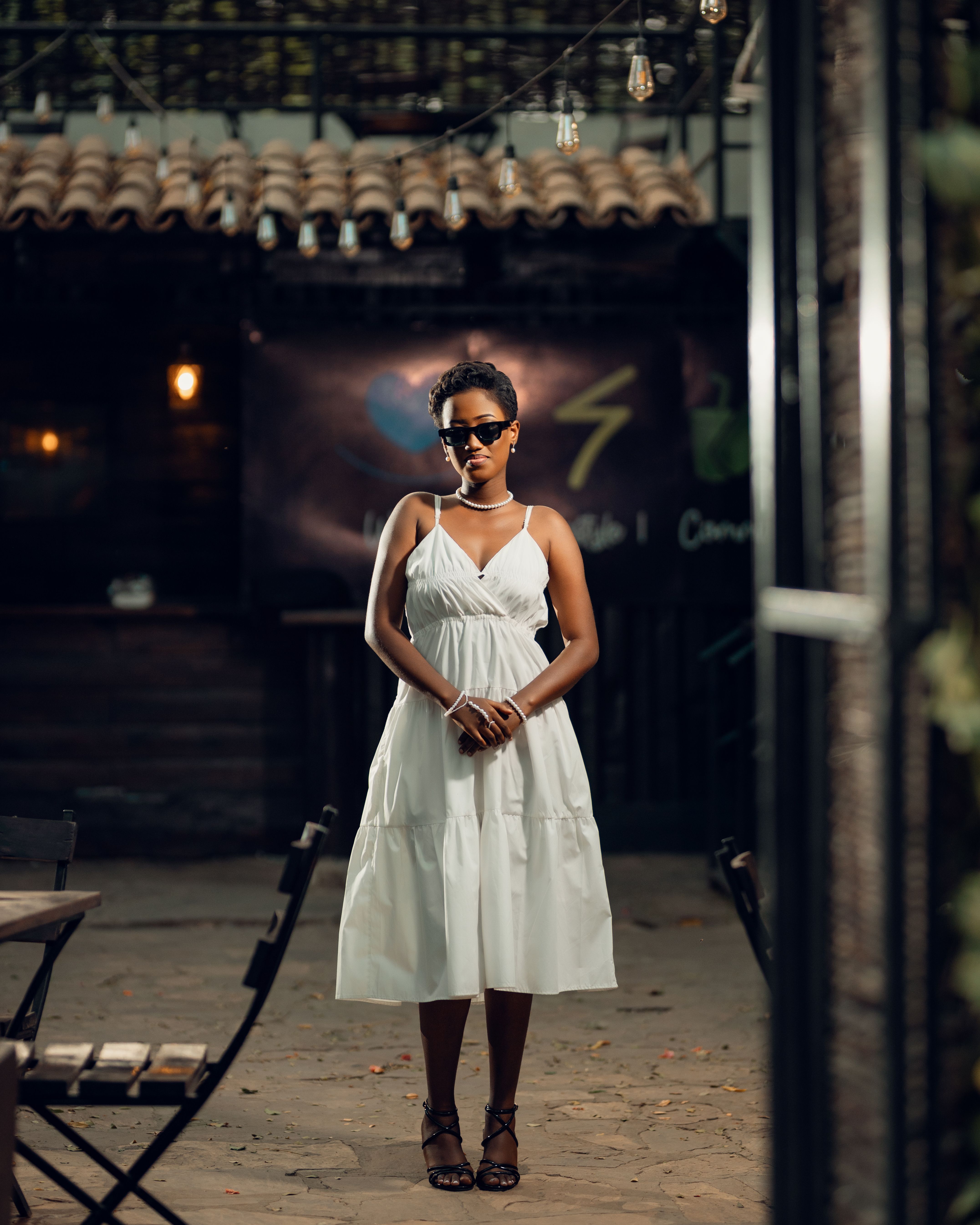 Elegant Woman in White Dress at Outdoor Cafe · Free Stock Photo