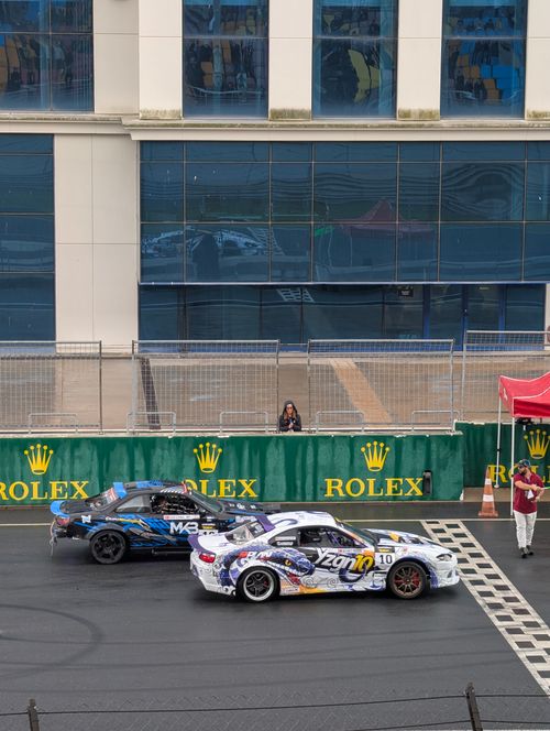 Free Two sports cars at a race track with Rolex branding in the backdrop and a cheering crowd. Stock Photo