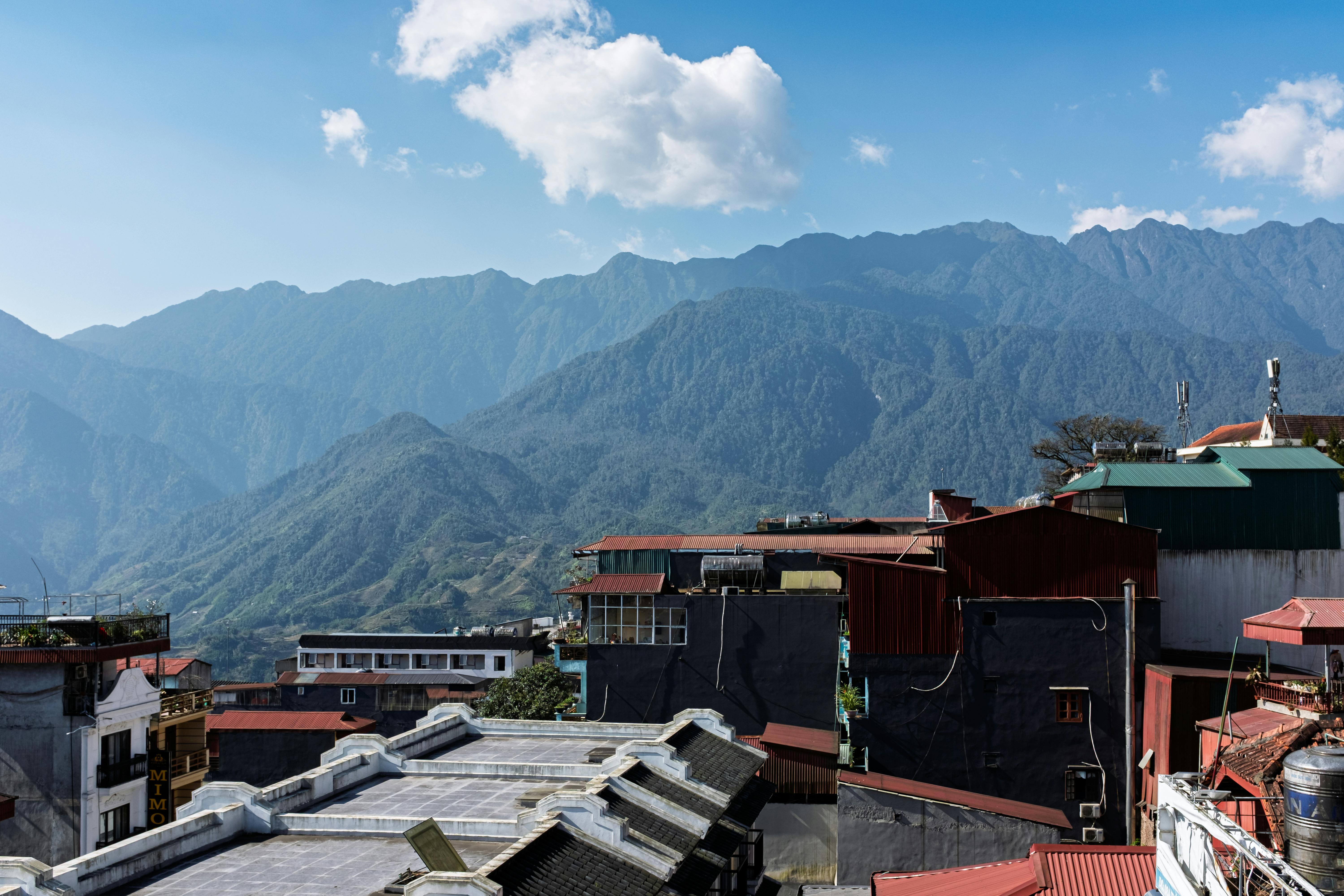 Rooftops of Sapa with dramatic mountains in the background on a clear day.