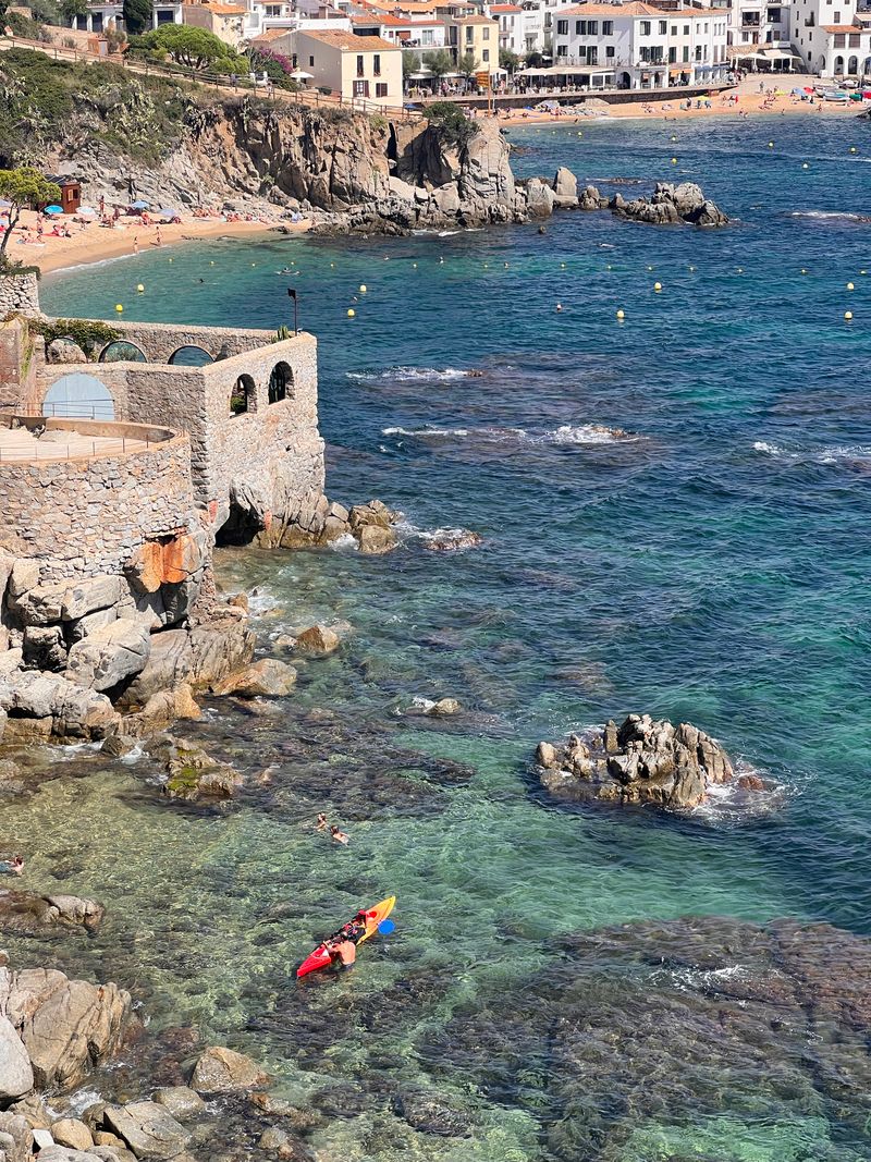 Stone arch on the coast with kayaker