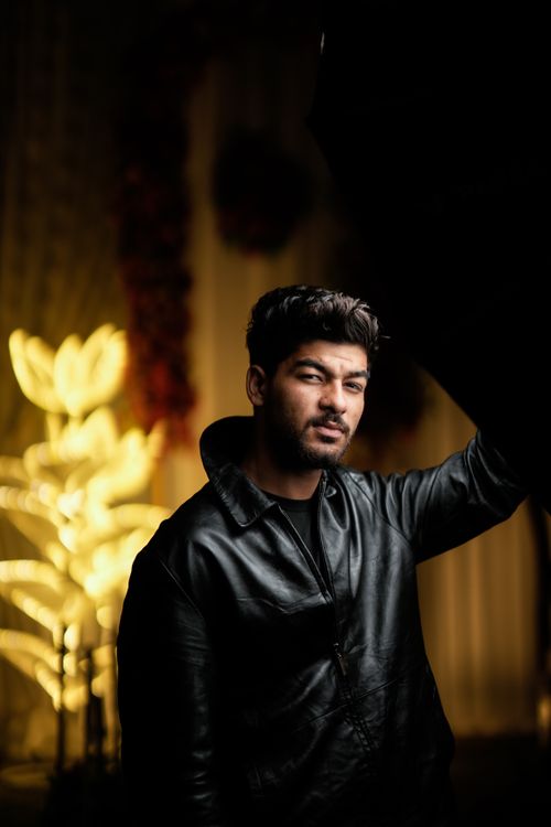 Free Portrait of a man in a black leather jacket with dramatic moody lighting indoors. Stock Photo