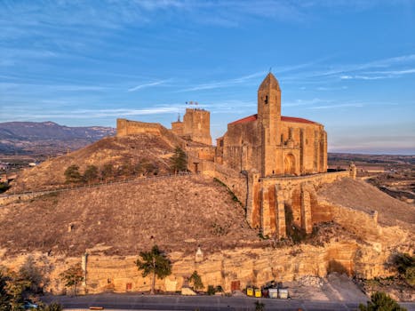Dramatic aerial shot of a historic castle in La Rioja, Spain during golden hour.