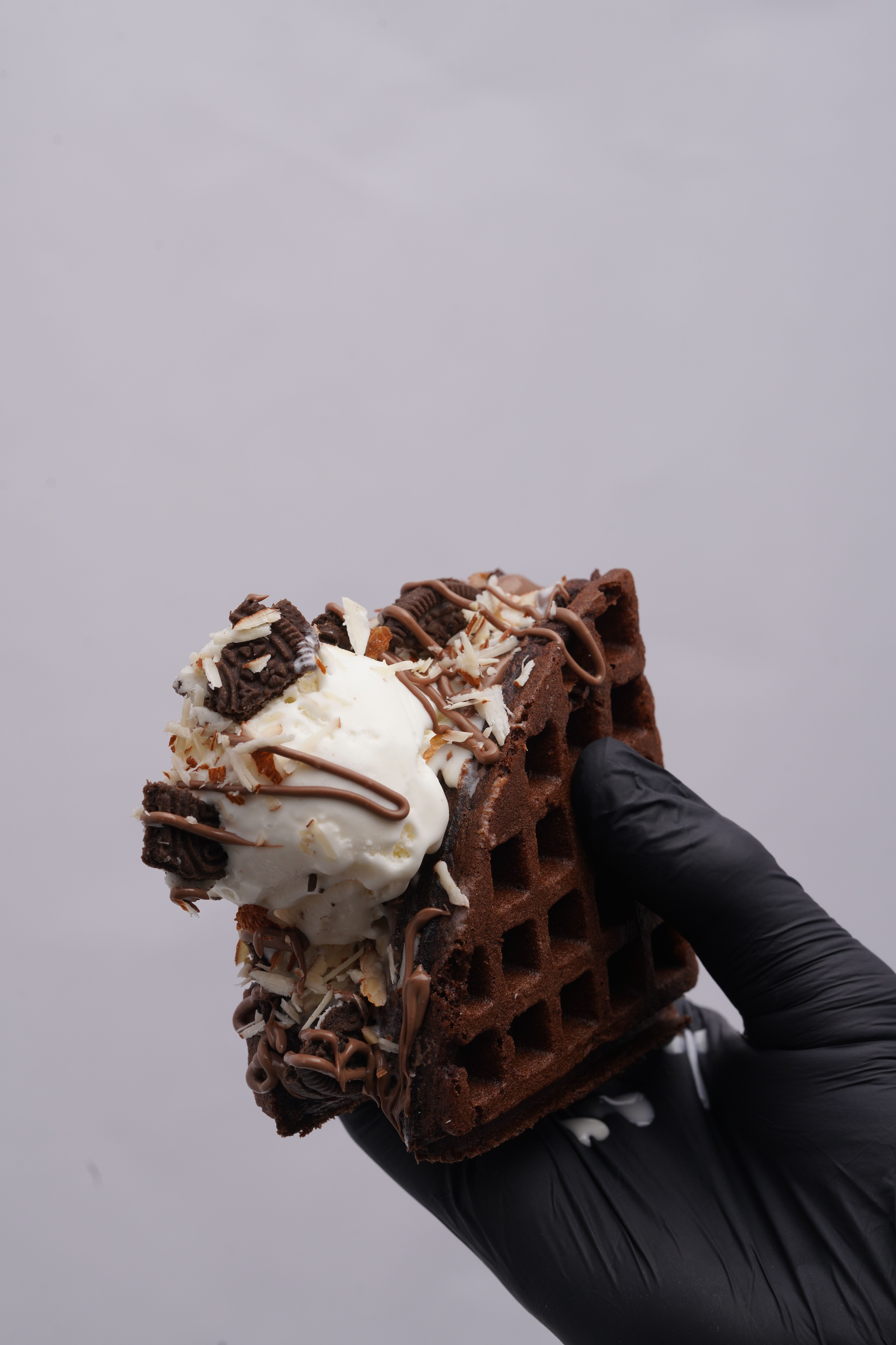Hand Holding Chocolate Waffle Ice Cream Sandwich · Free Stock Photo