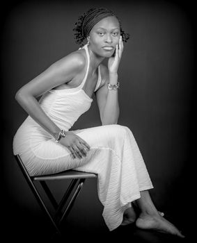 Sophisticated black and white portrait of a woman in an elegant gown, seated gracefully.