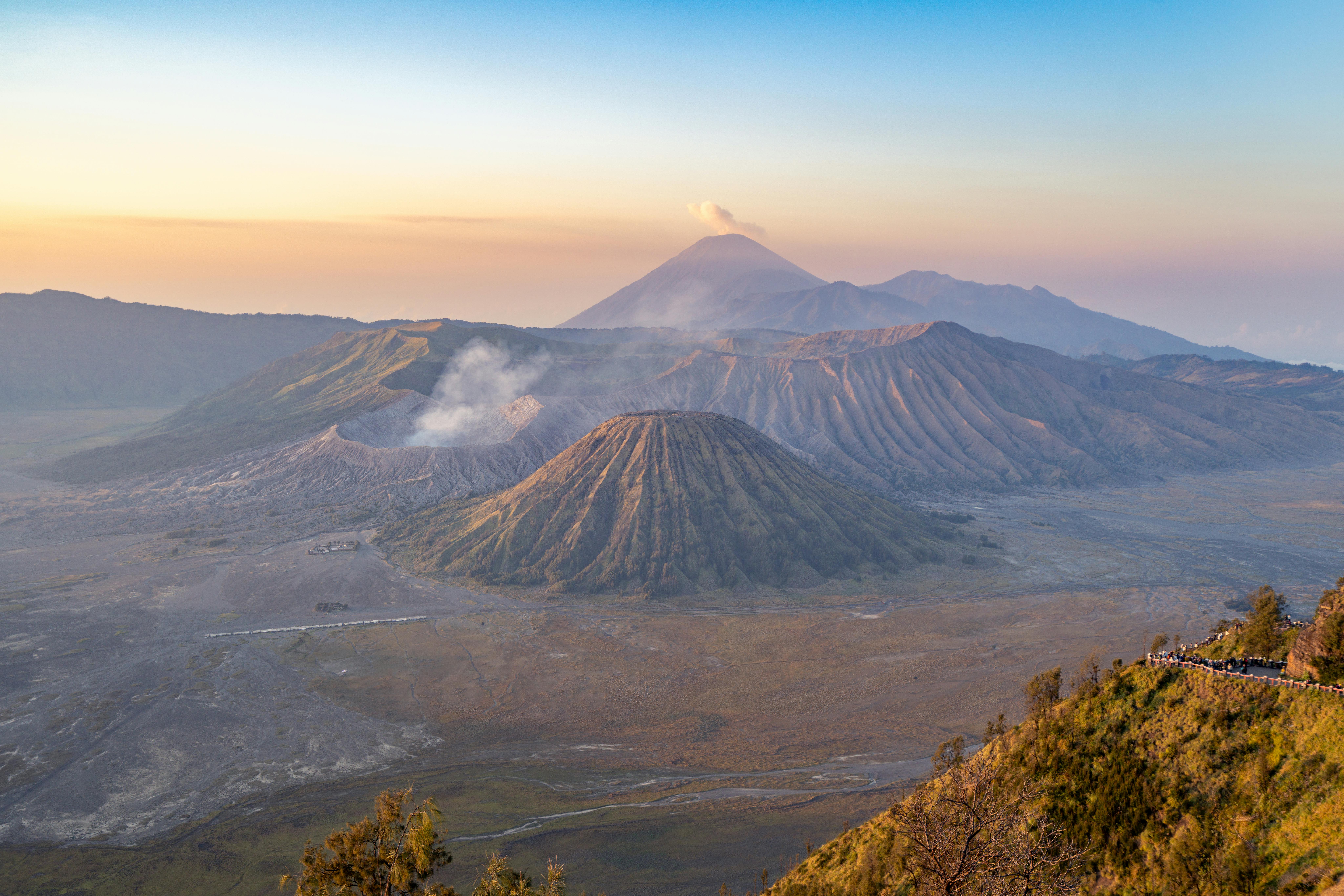 Captivating sunrise view of Mount Bromo with smoke and colorful sky in Indonesia.