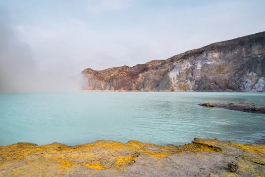 Serene landscape featuring the turquoise waters of Kawah Ijen crater lake, famous for its sulfur mining.
