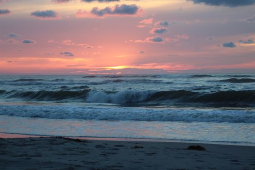 A tranquil sunset over waves at a beach in Friesland, Netherlands.