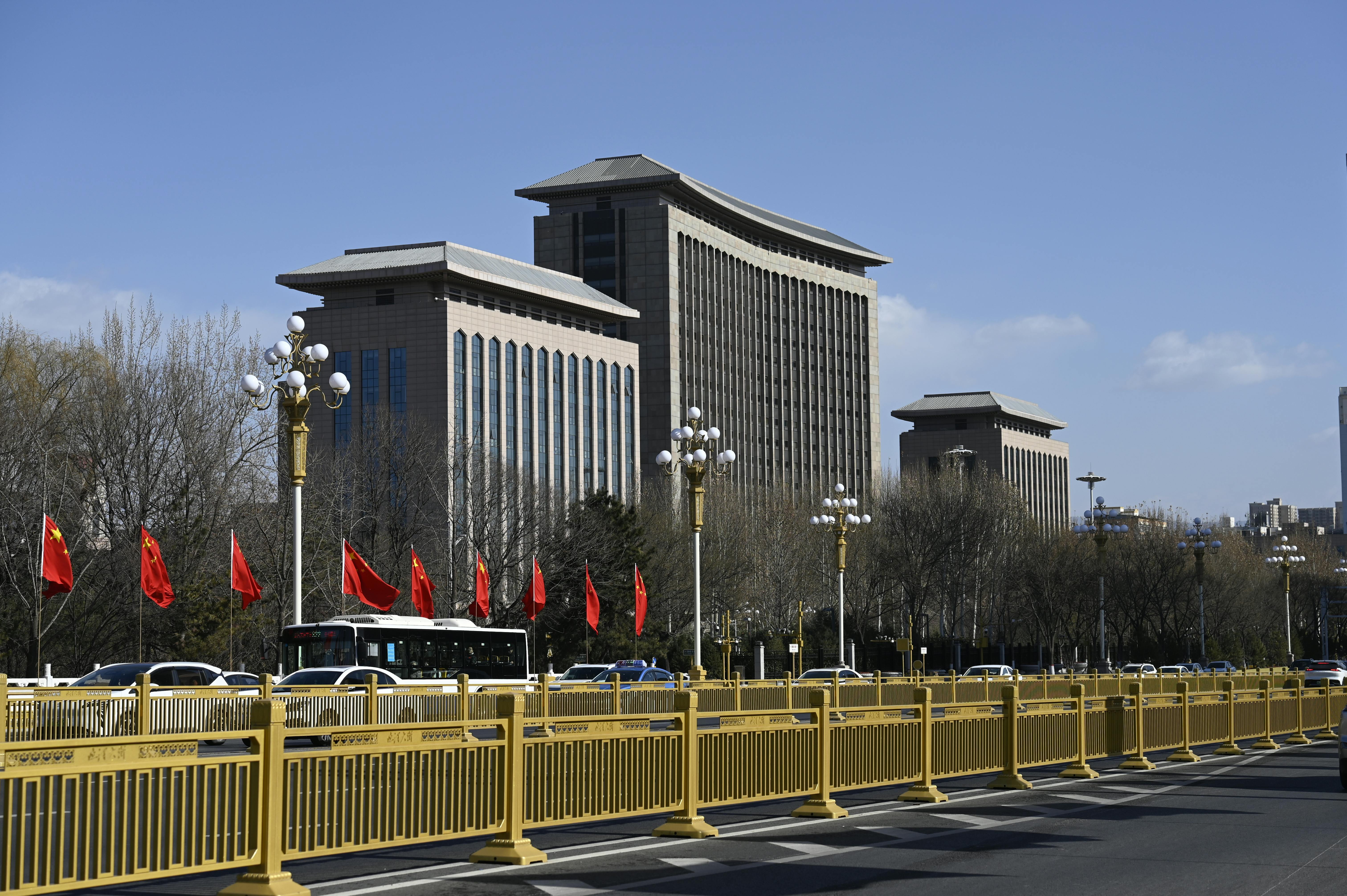 Street view of modern buildings with red flags in Beijing on a clear day.