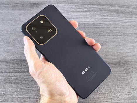 Detailed shot of a person holding a sleek smartphone with a visible camera module.