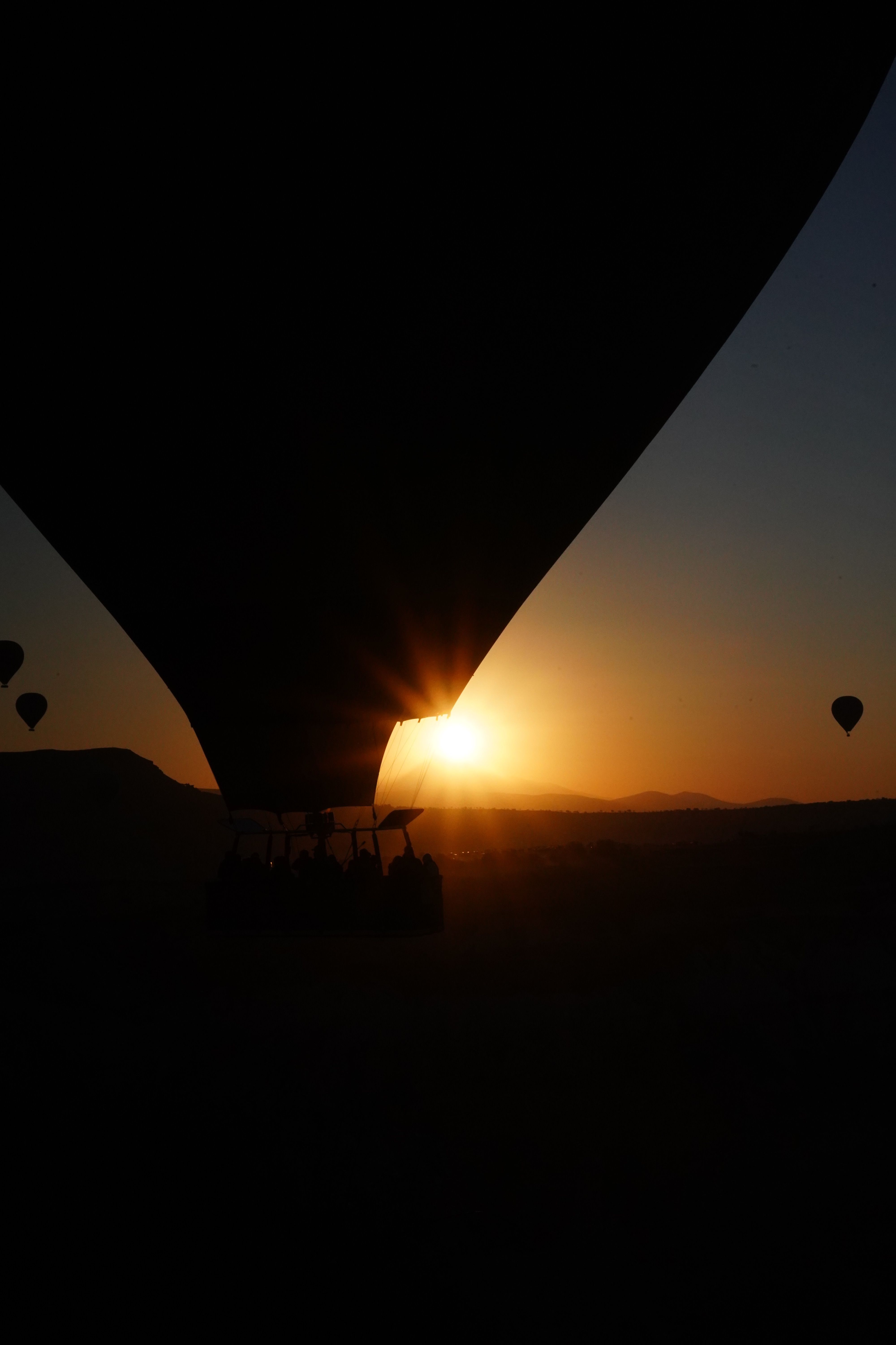 Hot Air Balloons at Sunset Over Scenic Landscape · Free Stock Photo