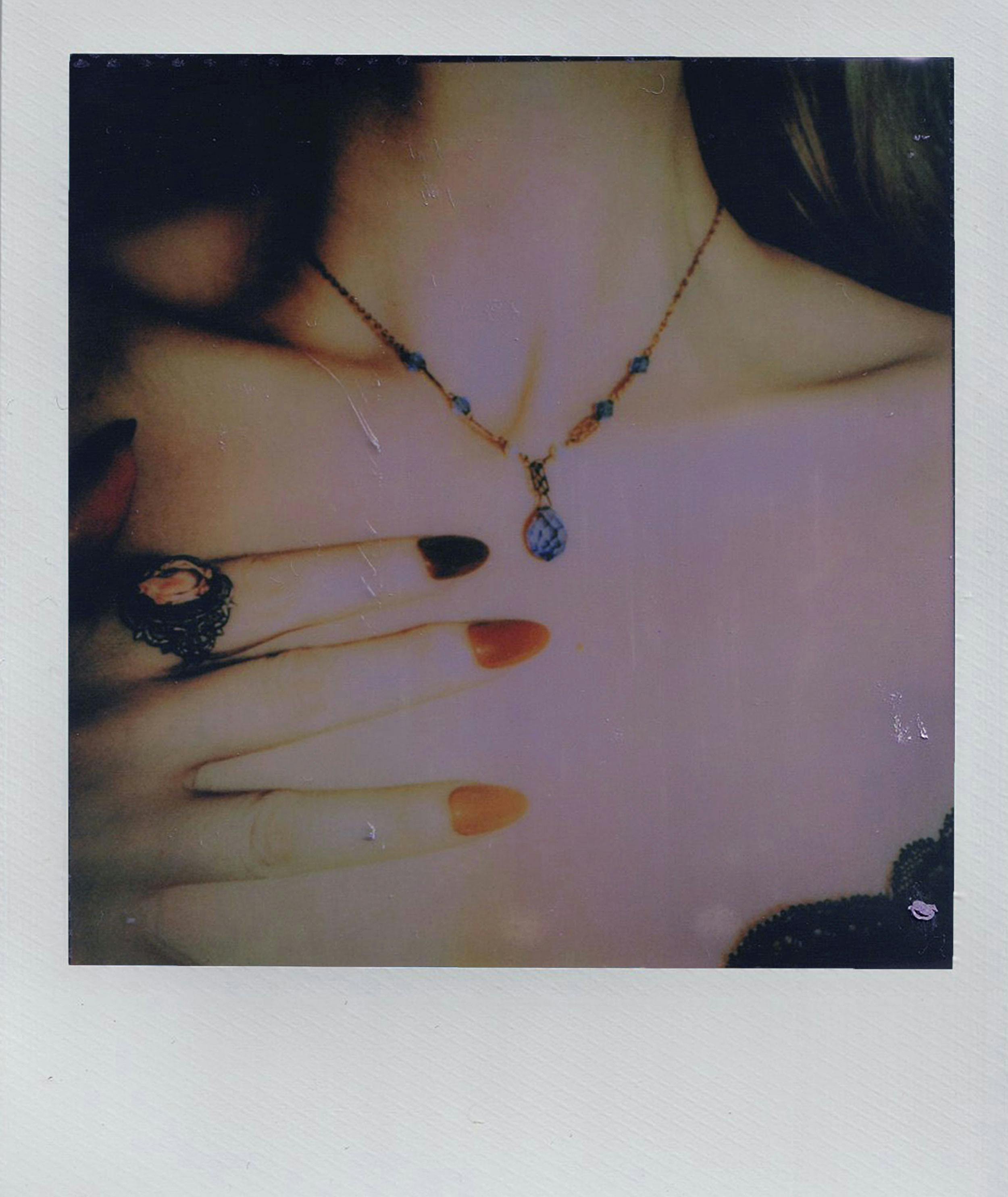 A close-up of elegant jewelry featuring a necklace and ring against a soft vintage background.