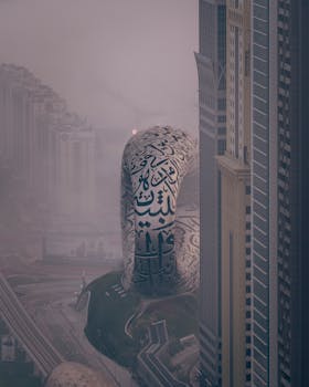 A moody, foggy landscape showcasing Dubai's iconic Museum of the Future among skyscrapers.