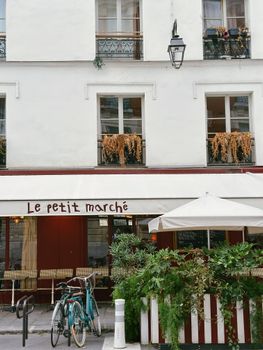 A quaint Parisian café with outdoor seating and bicycles parked in front. Perfect French charm.