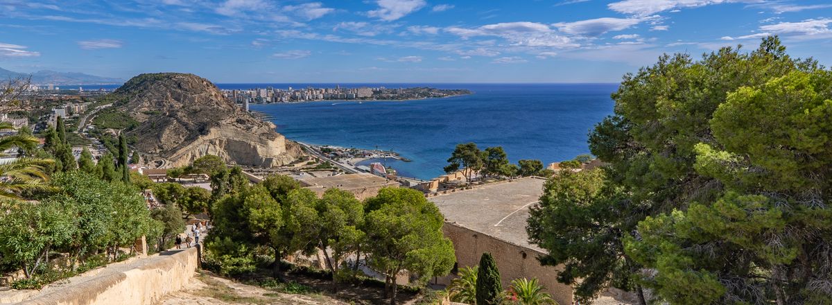 Stunning ocean and cityscape view from Alicante, Spain under a bright blue sky.