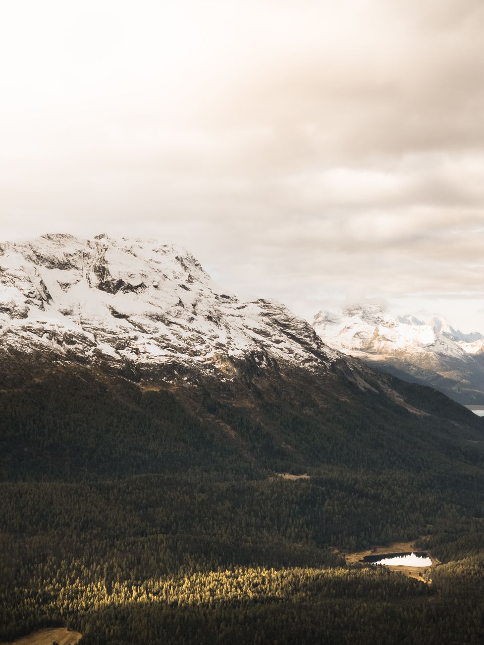 Beautiful snow-covered mountain peaks rise majestically under cloudy skies.
