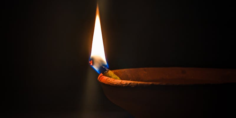 Lit diya lamp casting warm glow representing Vastu energy balance