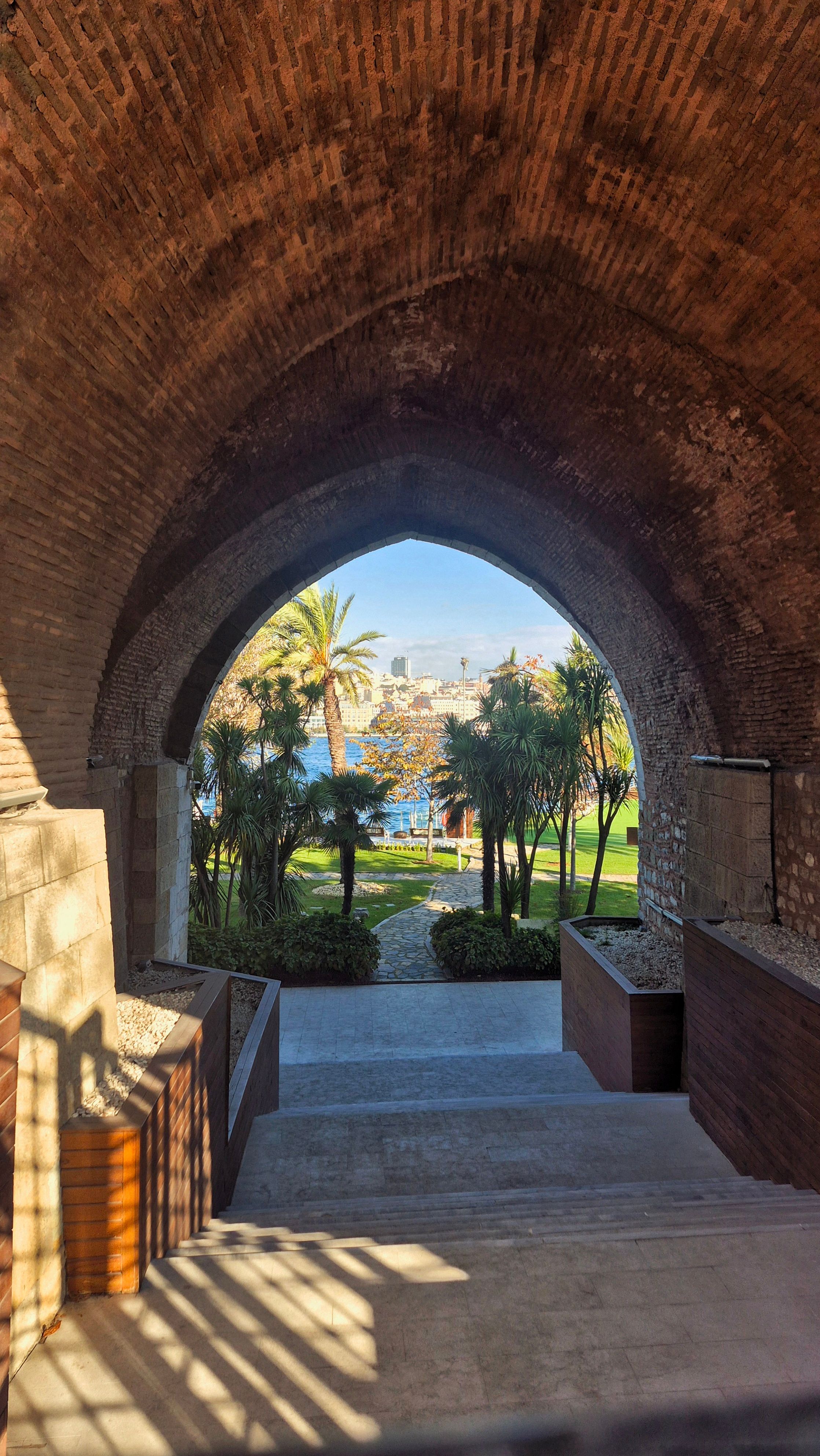 Historic Arched Entrance Overlooking Garden and Water · Free Stock Photo