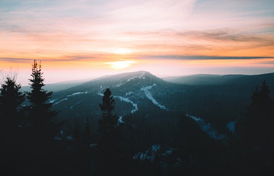 Serene sunrise view over snow-covered Lutsen mountains, capturing the peaceful winter landscape.