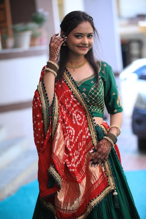 Free A young woman wearing traditional Indian clothing, smiling at the camera outdoors. Stock Photo