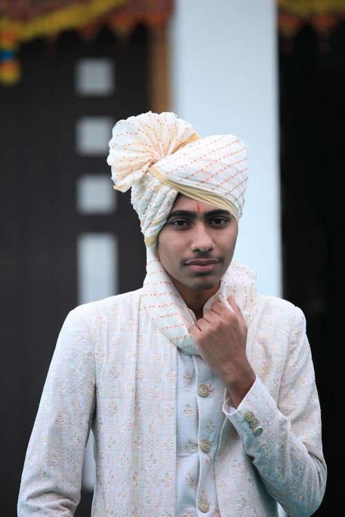 Free Portrait of a young man wearing traditional Indian wedding attire with a turban. Stock Photo
